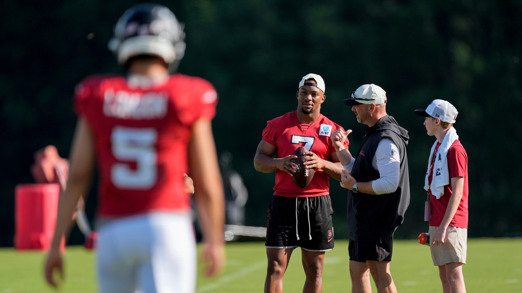 Atlanta Falcons running back Bijan Robinson (7) speak to a coach during a Atlanta Falcons training camp, Monday, Aug. 3, 2026, in Flowery Branch, Ga. (AP Photo/Mike Stewart)
