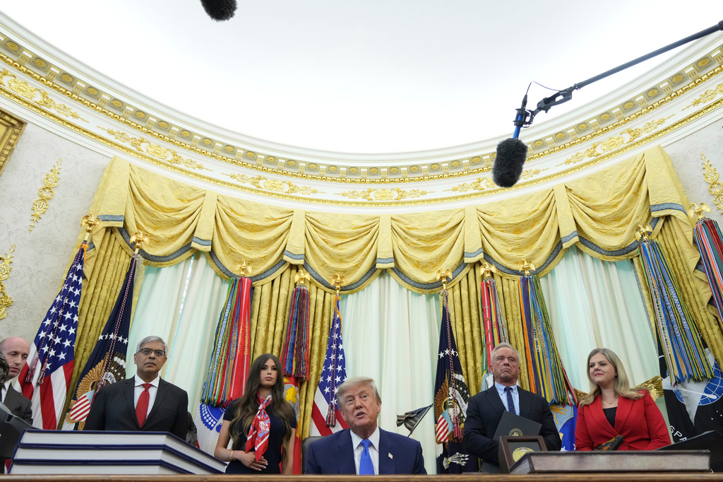 President Donald Trump speaks as Stephen Miller, White House deputy chief of staff, from left, National Institutes of Health Director Dr. Jay Bhattacharya, Jayme Franklin, Health and Human Services Secretary Robert F. Kennedy Jr. and Heidi Overton, deputy director of the White House Domestic Policy Council, listen during a meeting to sign an executive order about vaccines, Monday, Aug. 10, 2026, in the Oval Office of the White House in Washington. (AP Photo/Jacquelyn Martin)