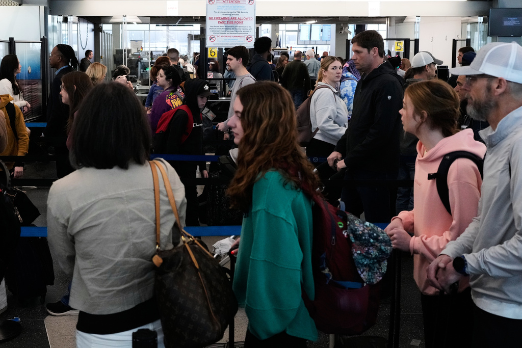 Travelers line up at a TSA checkpoint at O'Hare International Airport in Chicago, Tuesday, March 24, 2026. (AP Photo/Nam Y. Huh)
