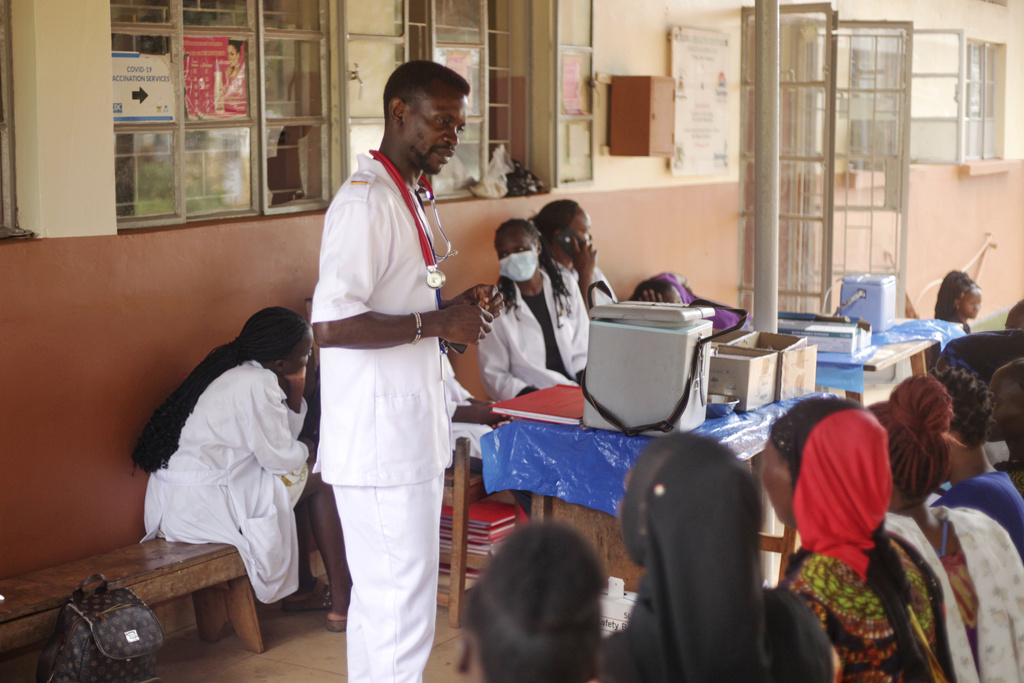 A health worker talks to patients at Wakiso Health Centre IV in Kampala, Wakiso, Tuesday, July 22, 2025. (AP Photo/Patrick Onen)