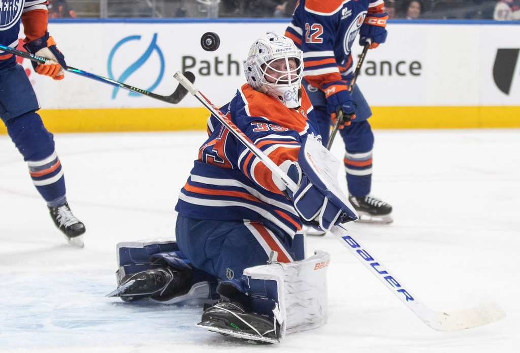 Edmonton Oilers' goalie Connor Ingram, center, makes a save against the Vegas Golden Knights during first-period NHL hockey game action in Edmonton, Alberta, Sunday, Dec. 21, 2025. (Jason Franson/The Canadian Press via AP)
