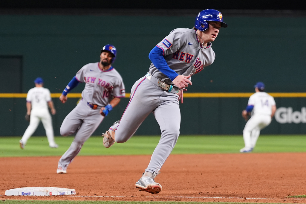 New York Mets' Carson Benge, front, and Marcus Semien (10) round third as the two score on a Francisco Alvarez double in the sixth inning of a baseball game against the Texas Rangers Tuesday, Sept. 22, 2026, in Arlington, Texas. (AP Photo/Tony Gutierrez)