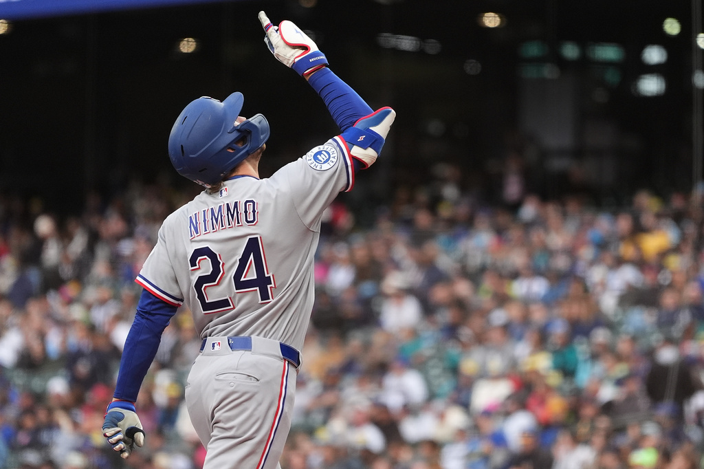 Texas Rangers' Brandon Nimmo points as he jogs home after hitting a solo home run against the Seattle Mariners during the first inning of a baseball game, Friday, April 17, 2026, in Seattle. (AP Photo/Lindsey Wasson)