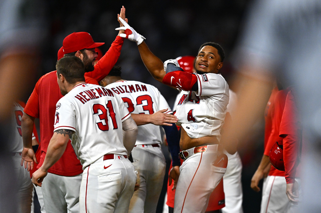 Los Angeles Angels' Christian Moore (4) is greeted by teammates after hitting a walk-off single during the 11th inning of a baseball game against the Minnesota Twins, Saturday, Sept. 19, 2026, in Anaheim, Calif. (AP Photo/William Liang)