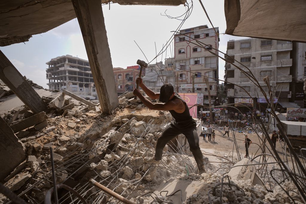 Palestinians remove iron from the rubble of buildings destroyed by Israeli airstrikes during the war with Hamas, repair and recycle it for construction, building tents or selling it, in Gaza City, Sunday, Aug. 16, 2026. (AP Photo/Jehad Alshrafi)