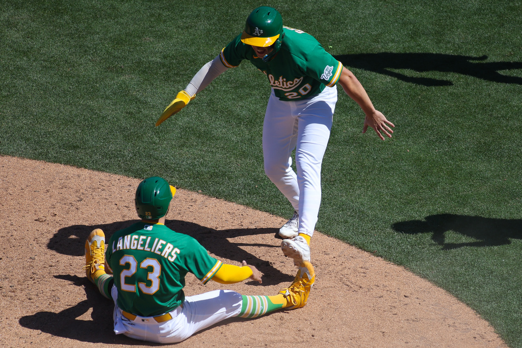 Athletics' Zack Gelof (20) prepares to celebrate with Shea Langeliers (23) after they scored during the eighth inning of a baseball game against the Texas Rangers, Thursday, April 16, 2026, in West Sacramento, Calif. (AP Photo/Scott Marshall)