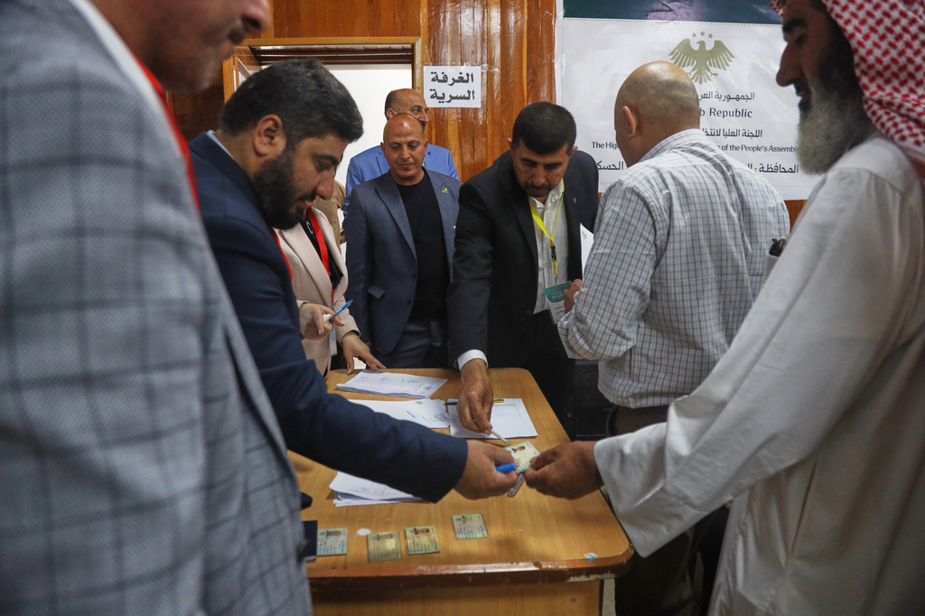 Election officials verify voters' identification documents during follow-up parliamentary elections in Hassakeh, northeastern Syria, Sunday, May 24, 2026. (AP Photo/Baderkhan Ahmad)