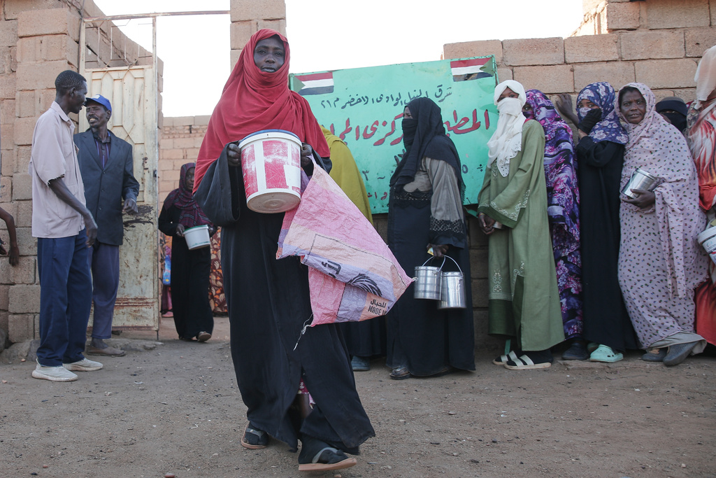 A woman carries food as she leaves a charity kitchen in Khartoum, Sudan, Wednesday, Jan. 21, 2026. (AP Photo/Marwan Ali)
