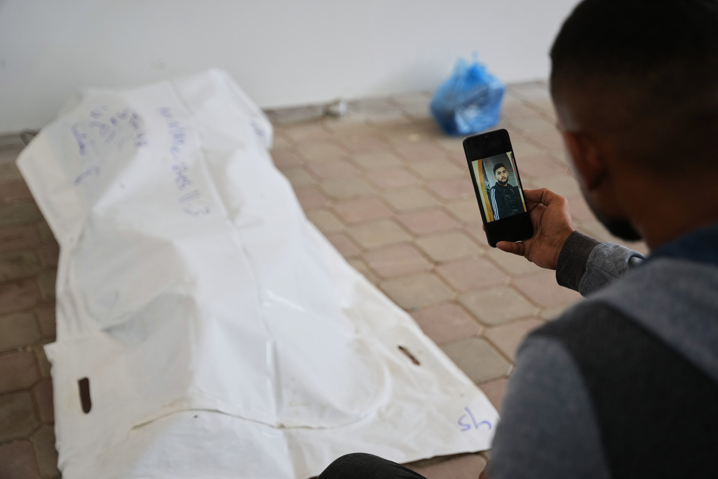 A relative shows a photo of Rami Assaf after his body was identified by his family. His remains were returned from Israel as part of the cease-fire deal and brought to Nasser Hospital in Khan Younis, Gaza Strip, Saturday, Nov. 8, 2025. (AP Photo/Abdel Kareem Hana)