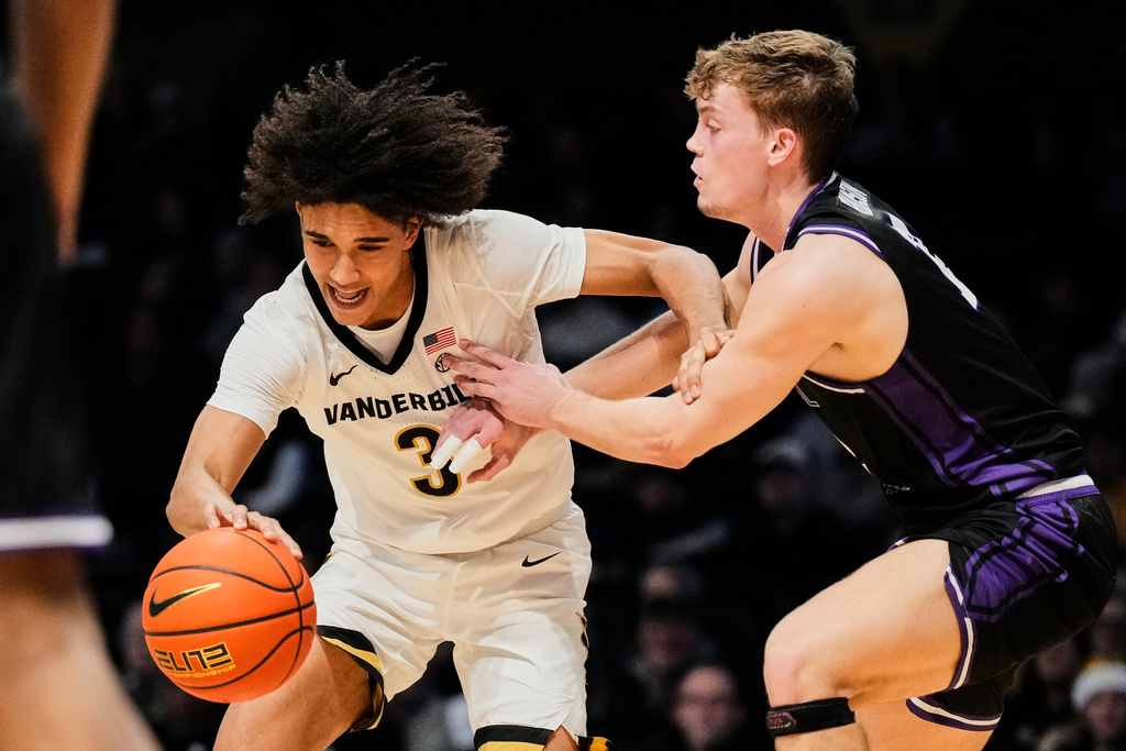Vanderbilt guard Tyler Tanner (3) dribbles the ball past Central Arkansas guard Ty Robinson (12) during the first half of an NCAA college basketball game Saturday, Dec. 13, 2025, in Nashville, Tenn. (AP Photo/George Walker IV)