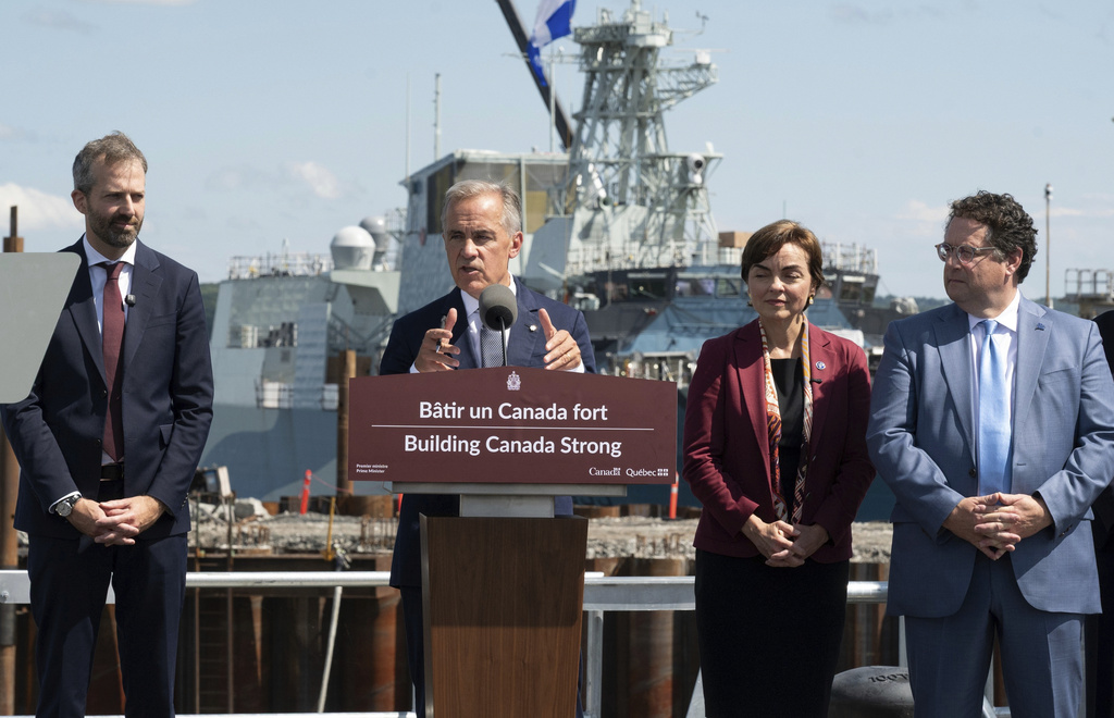 Canadian Prime Minister Mark Carney, center, speaks at the Davie shipyard in Levis, Quebec on Monday, Aug. 24, 2026. Joël Lightbound, Minister of Government Transformation, Public Works and Procurement, left, Quebec Premier Christine Frechette, and Quebec Minister of Economy, Innovation and Energy and Minister Responsible for Maritime Strategy Bernard Drainville look on. (Jacques Boissinot/The Canadian Press via AP)