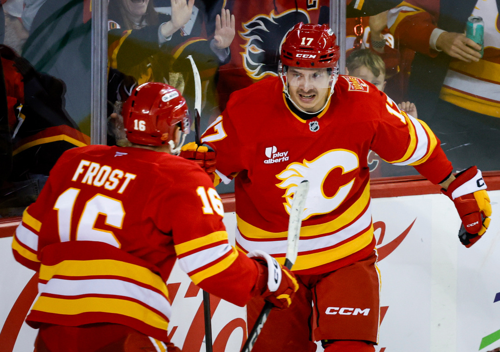 Calgary Flames' Yegor Sharangovich, right, celebrates his goal with teammate Morgan Frost during the third period of an NHL hockey game against the Carolina Hurricanes in Calgary, Alberta, Sunday, Oct. 18, 2026. (Jeff McIntosh/The Canadian Press via AP)