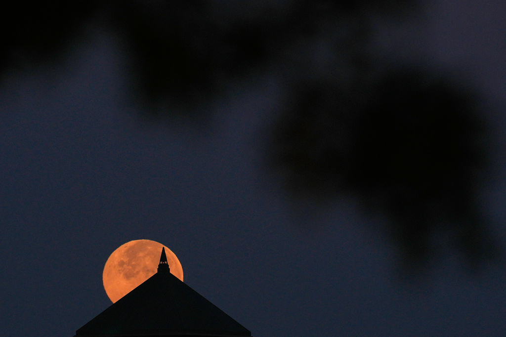 The full beaver supermoon sets beyond an office building Wednesday, Nov. 5, 2025, in Overland Park, Kan. (AP Photo/Charlie Riedel)