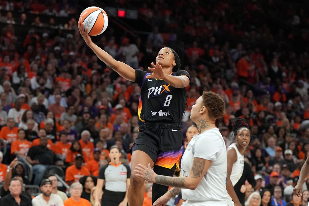Phoenix Mercury guard Monique Akoa Makani (8) shoots over Las Vegas Aces forward Kierstan Bell during the second half of Game 3 of the WNBA basketball finals, Wednesday, Oct. 8, 2025, in Phoenix. (AP Photo/Rick Scuteri)