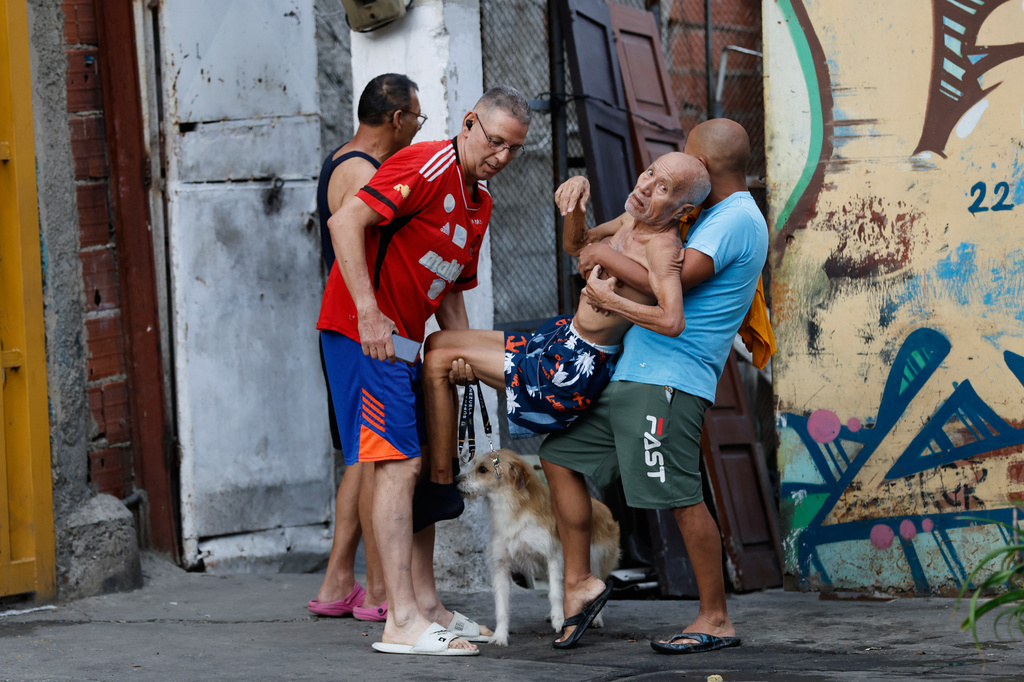 Neighbors helps a man evacuate his damaged home after an earthquake in Caracas, Venezuela, Wednesday, June 24, 2026.(AP Photo/Pedro Mattey)