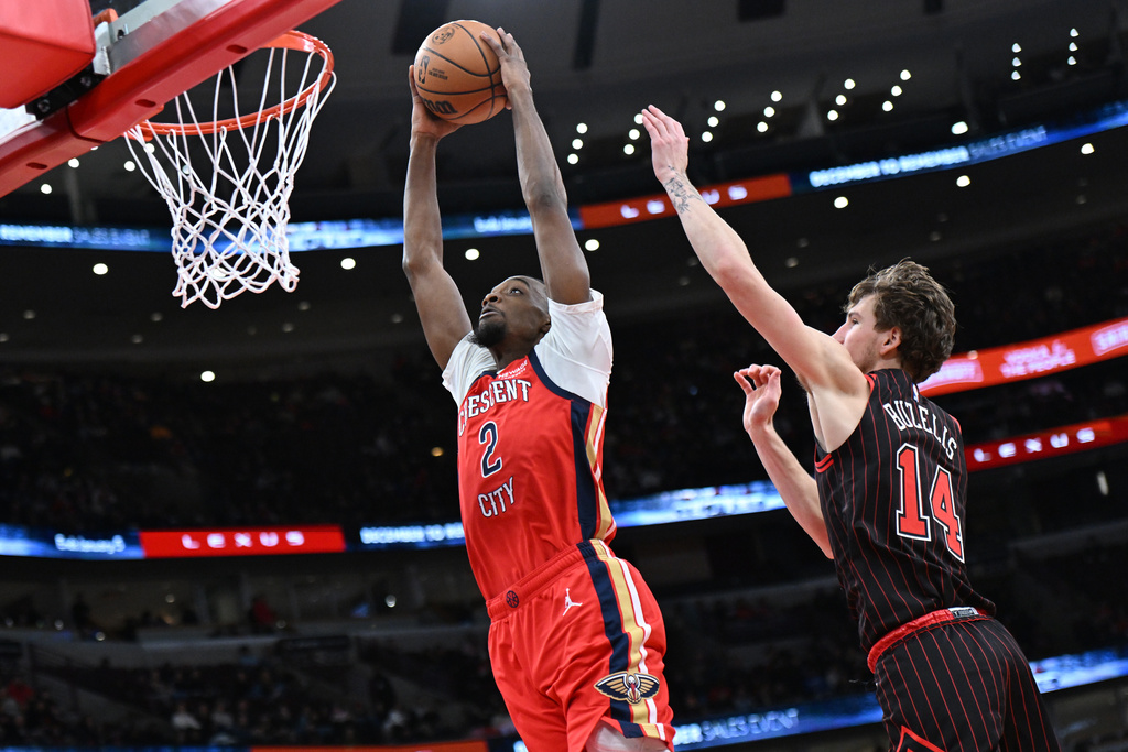 New Orleans Pelicans' Herb Jones (2) goes up for a dunk against Chicago Bulls' Matas Buzelis (14) during the first half of an NBA basketball game Sunday, Dec. 14, 2025, in Chicago. (AP Photo/Paul Beaty)
