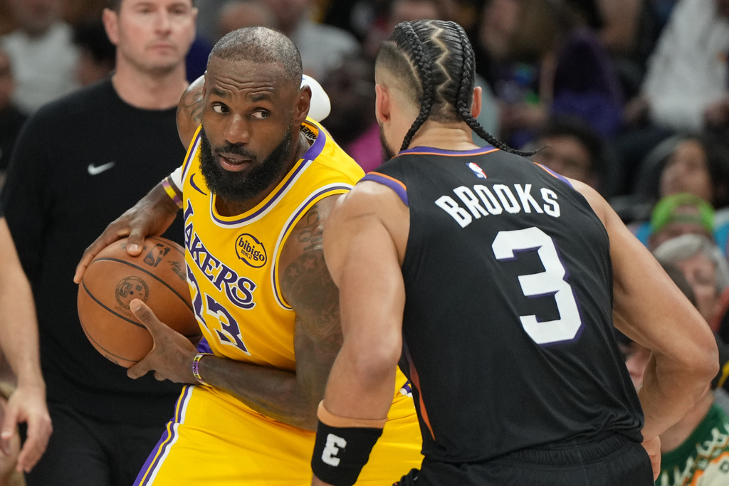 Los Angeles Lakers forward Lebron James squares up to Phoenix Suns forward Dillon Brooks (3) during the first half of an NBA basketball game, Tuesday, Dec. 23, 2025, in Phoenix. (AP Photo/Rick Scuteri)