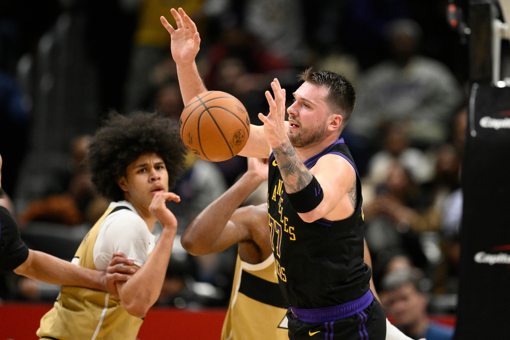 Los Angeles Lakers guard Luka Doncic, right, chases the ball during the first half of an NBA basketball game against the Washington Wizards, Friday, Jan. 30, 2026, in Washington. (AP Photo/Nick Wass)