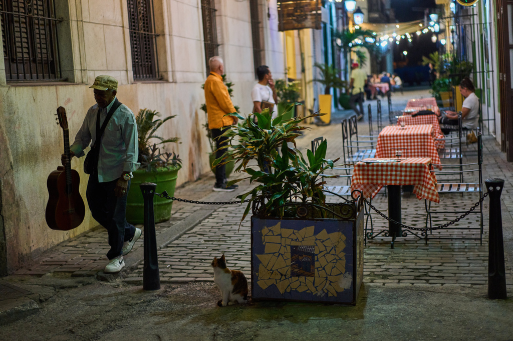 A street musician walks past a restaurant in Havana, Wednesday, April 15, 2026. (AP Photo/Ramon Espinosa)