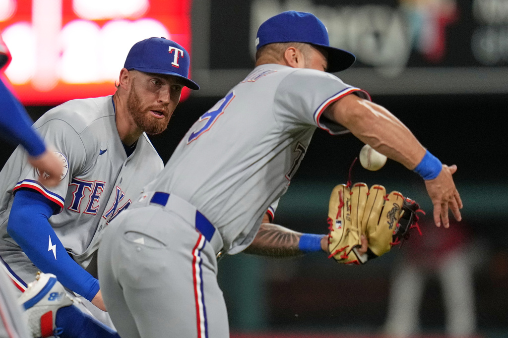 Texas Rangers right fielder Brandon Nimmo watch as second baseman Cody Freeman, right, catches a pop up by St. Louis Cardinals' Masyn Winn for an out during the sixth inning of a baseball game Wednesday, June 3, 2026, in St. Louis. (AP Photo/Jeff Roberson)