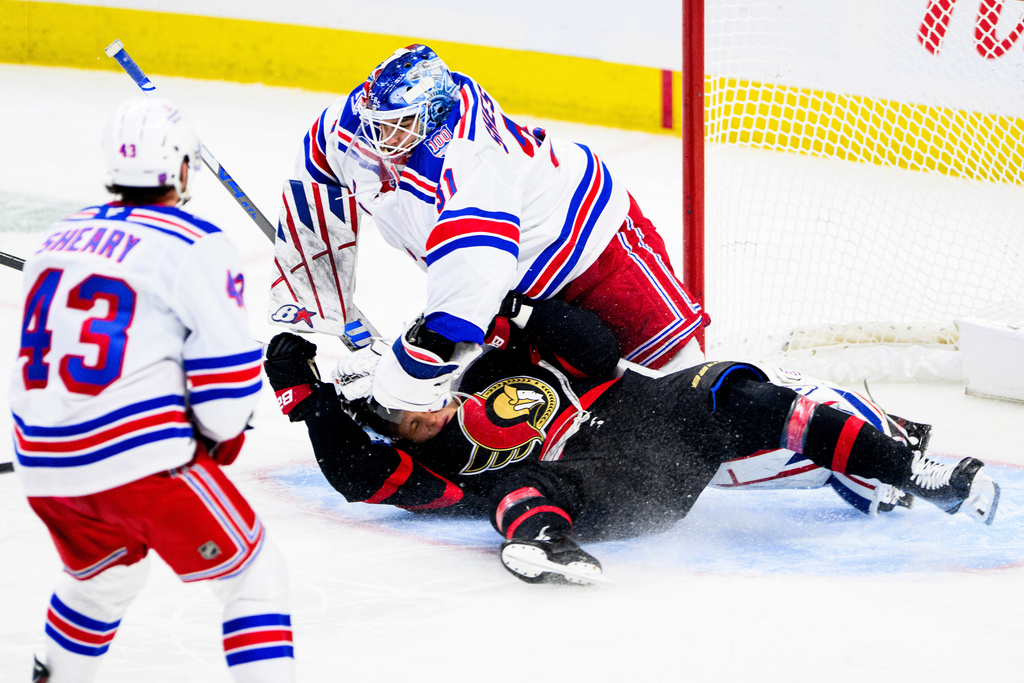 Ottawa Senators' Tim Stutzle (18) crashes into New York Rangers goaltender Igor Shesterkin (31) on a breakaway during third period NHL hockey action in Ottawa, on Thursday, Dec. 4, 2025. (Spencer Colby/The Canadian Press via AP)