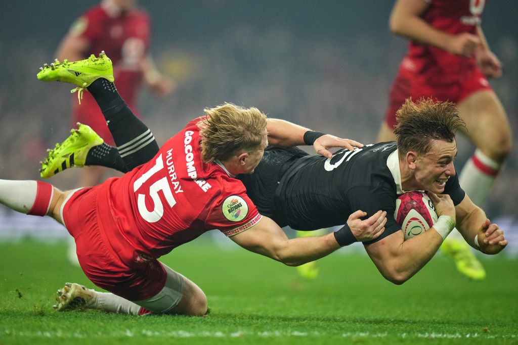 New Zealand's Ruben Love scores a try despite the challenge of Wales' Blair Murray during the Nation's Series rugby union international between Wales and New Zealand in Cardiff, Wales, Saturday, Nov. 22, 2025. (AP Photo/Alastair Grant)