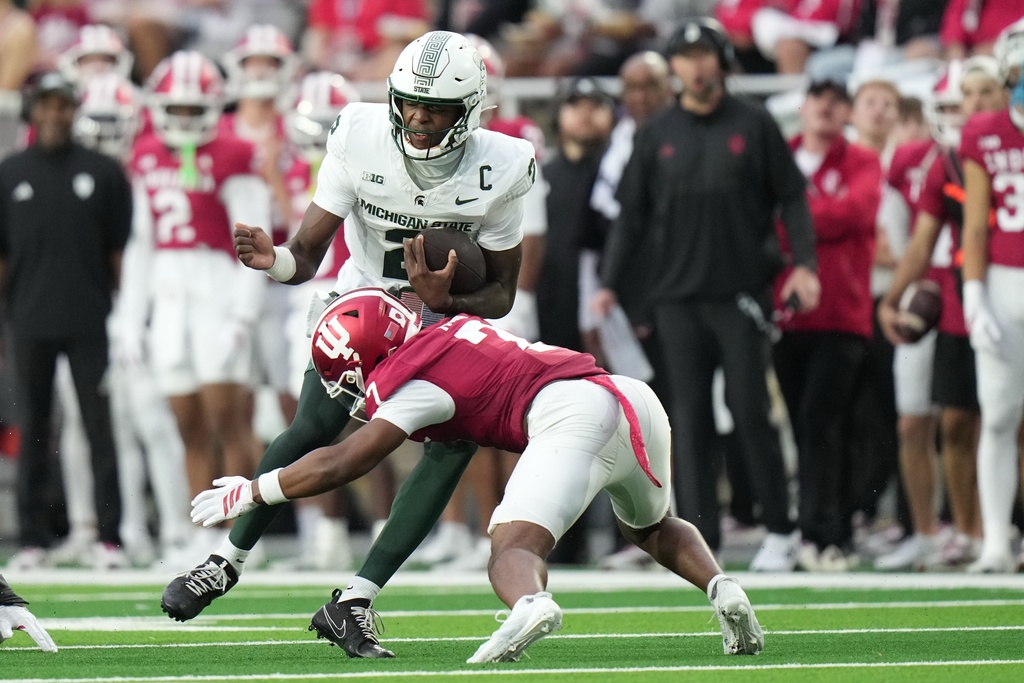 Michigan State quarterback Aidan Chiles (2) is tackled by Indiana defensive back Louis Moore (7) during the second half of an NCAA college football game, Saturday, Oct. 18, 2025, in Bloomington, Ind. (AP Photo/AJ Mast)