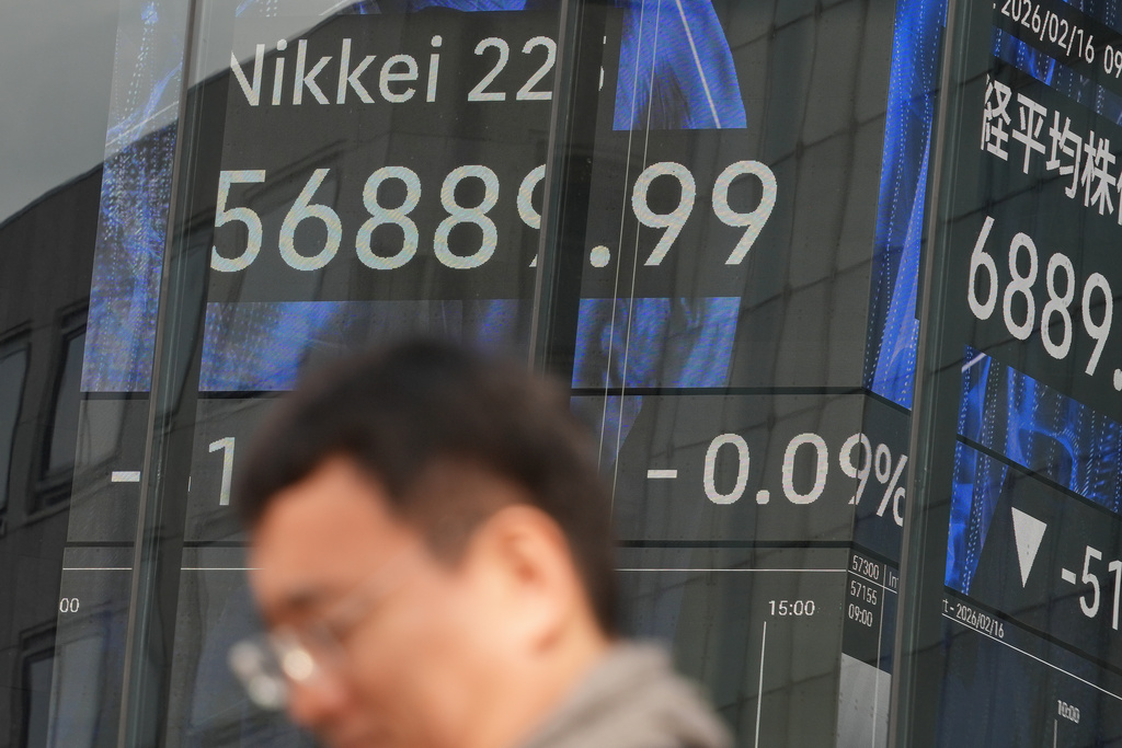 A person stands in front of an electronic stock board showing Japan's Nikkei index at a securities firm Monday, Feb. 16, 2026, in Tokyo. (AP Photo/Eugene Hoshiko)
