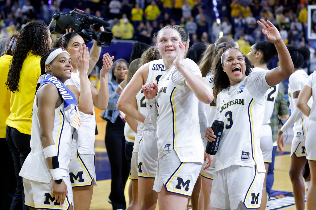 Michigan players, including Brooke Quarles Daniels, left, Olivia Olson, center, and Mila Holloway, right, celebrate in the first round of the NCAA college basketball tournament against Holy Cross, Friday, March 20, 2026, in Ann Arbor, Mich. (AP Photo/Al Goldis)