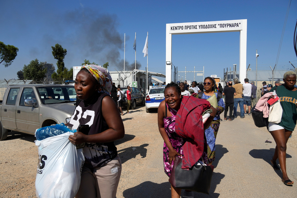 FILE - Female migrants exit the Pournara migrant reception center following fighting between rival groups inside the camp near the village of Kokkinotrimithia, on the outskirts of the capital Nicosia, Cyprus, Friday, Oct. 28, 2022. (AP Photo/Petros Karadjias, File)