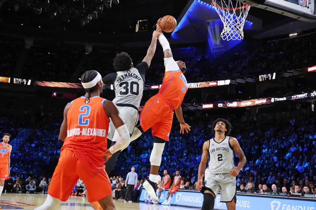 Oklahoma City Thunder guard Luguentz Dort (5) jumps to the basket near San Antonio Spurs forward Julian Champagnie (30) during the first half of an NBA Cup semifinals basketball game, Saturday, Dec. 13, 2025, in Las Vegas. (AP Photo/Ronda Churchill)