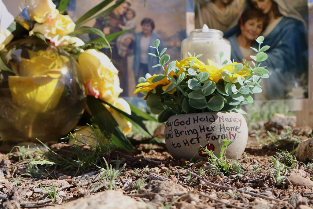 A hand-painted pot is part of a growing memorial outside the home of Nancy Guthrie, the missing mother of "Today" show host Savannah Guthrie, Sunday, Feb. 22, 2026, in Tucson, Ariz. (AP Photo/Felicia Fonseca)