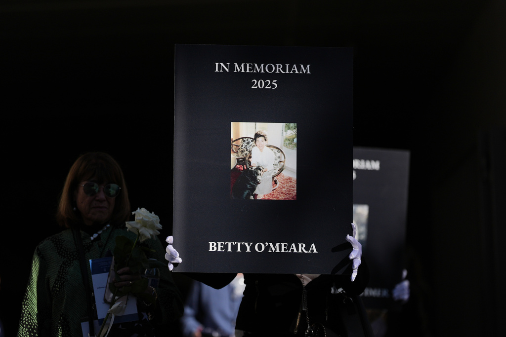 Photos of victims are carried on the one-year anniversary of the Palisades Fire in the Pacific Palisades neighborhood of Los Angeles Wednesday, Jan. 7, 2026. (AP Photo/Jae C. Hong)