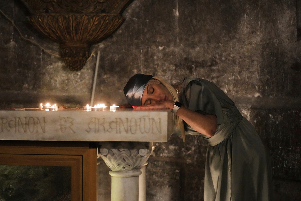 A Christian pilgrim rests her head while praying during Easter Sunday Mass at the Church of the Holy Sepulcher, in Jerusalem's Old City, April 20, 2025. (AP Photo/Mahmoud Illean, File)