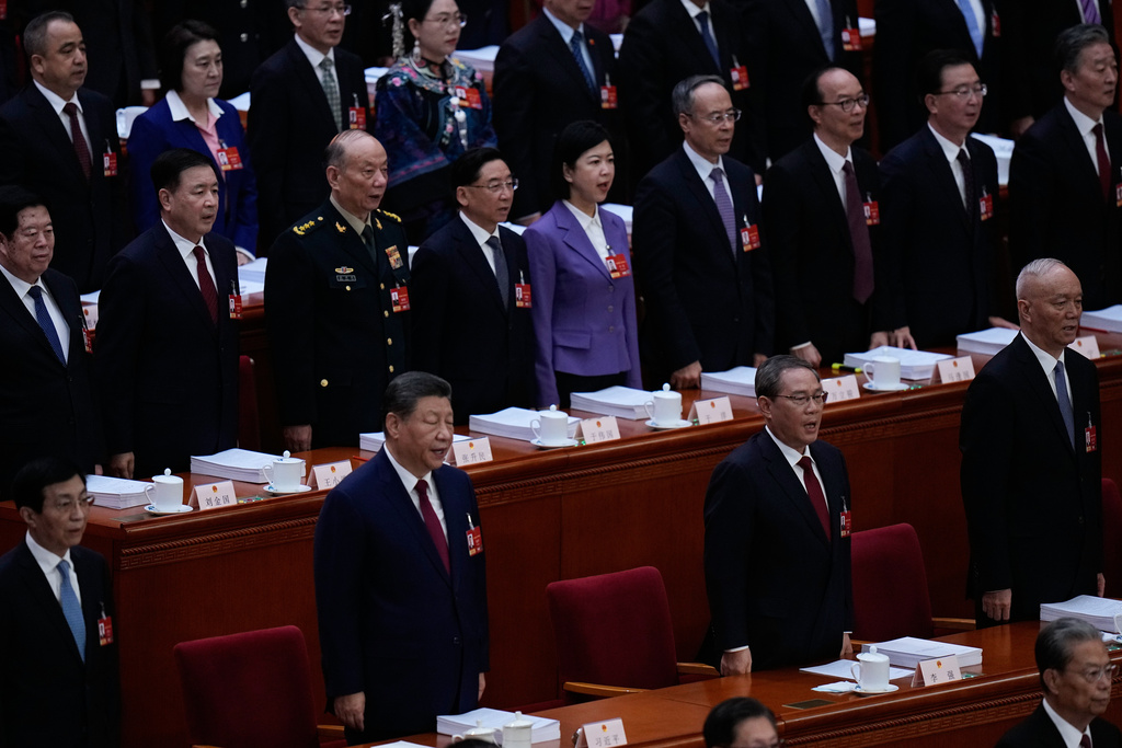 Chinese President Xi Jinping, second from left, and Chinese Premier Li Qiang, second from right, stand as they sing the national anthem during the opening session of the National People's Congress (NPC) in Beijing, Thursday, March 5, 2026. (AP Photo/Andy Wong)
