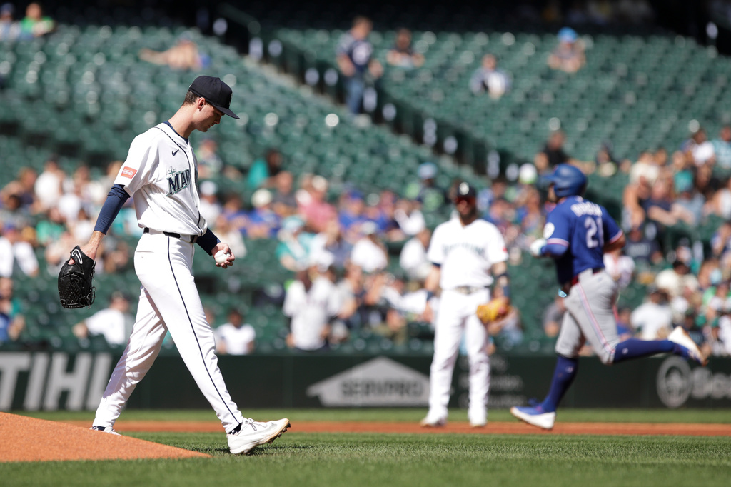 Seattle Mariners starting pitcher Kade Anderson, left, looks on as Texas Rangers Jake Burger (21) rounds the bases after hitting a home run during the second inning of a baseball game, Wednesday, Sept. 9, 2026, in Seattle. (AP Photo/Jason Redmond)