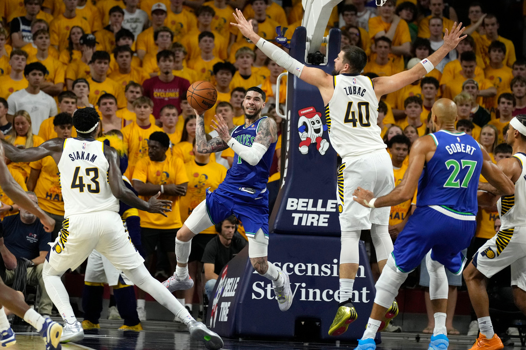 Minnesota Timberwolves guard LaMelo Ball, center, passes between Indiana Pacers forward Pascal Siakam (43) and center Ivica Zubac (40) during the first half of a preseason NBA basketball game, Wednesday, Oct. 7, 2026, in Ames, Iowa. (AP Photo/Charlie Neibergall)
