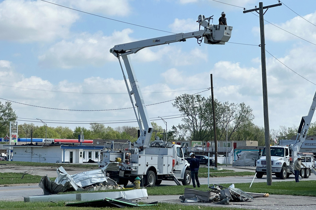 Crews work on power lines in Ottawa, Kansas, on Tuesday, April 14, 2026, following severe storms. (AP Photo/Nick Ingram)