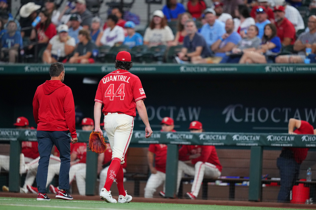 Texas Rangers starting pitcher Cal Quantrill (44) leaves the game with head athletic trainer Matt Lucero during the second inning of a baseball game against the Toronto Blue Jays, Saturday, Sept. 19, 2026, in Arlington, Texas. (AP Photo/Julio Cortez)
