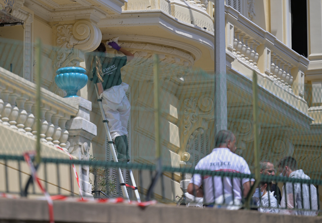 An investigator examines the scene at the residential building where an explosive device seriously injured three people a day earlier in Monaco, Tuesday, June 30, 2026. (AP Photo/Philippe Magoni)