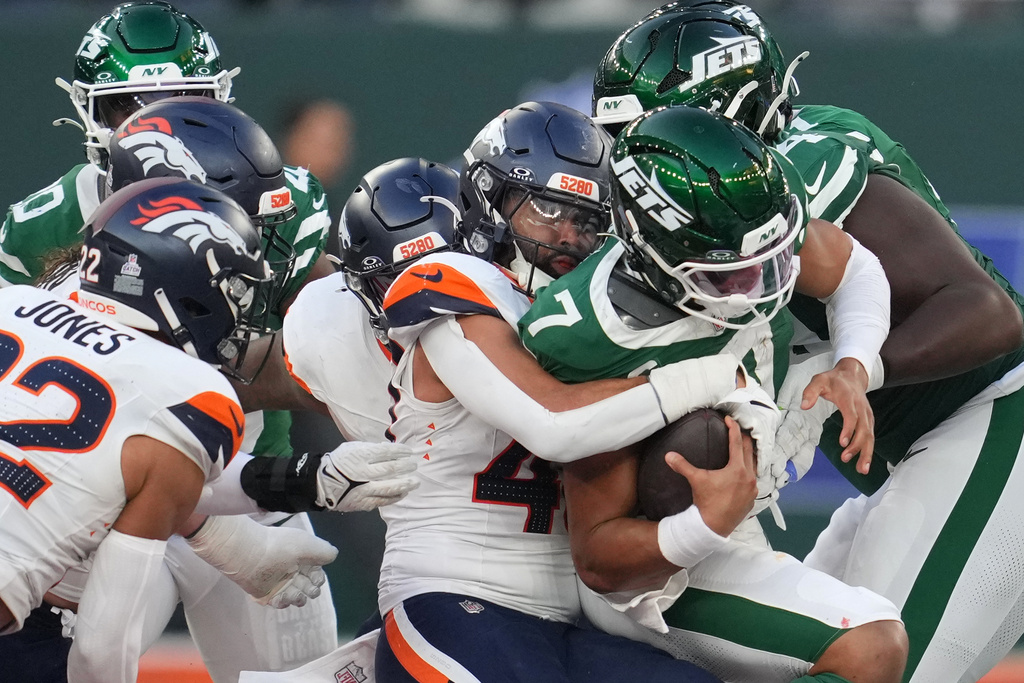 New York Jets quarterback Justin Fields (7) is tackled by the Broncos defense in the second half of an NFL football game between the Denver Broncos and the New York Jets, Sunday, Oct. 12, 2025, in London. (AP Photo/Kin Cheung)
