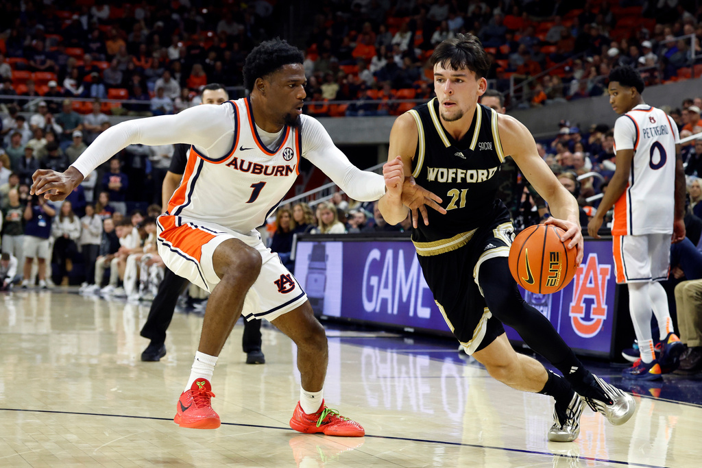 Wofford guard Nils MacHowski (21) drives the baseline around Auburn guard Kevin Overton (1) during the first half of an NCAA college basketball game, Tuesday, Nov. 11, 2025, in Auburn, Ala. (AP Photo/Butch Dill)
