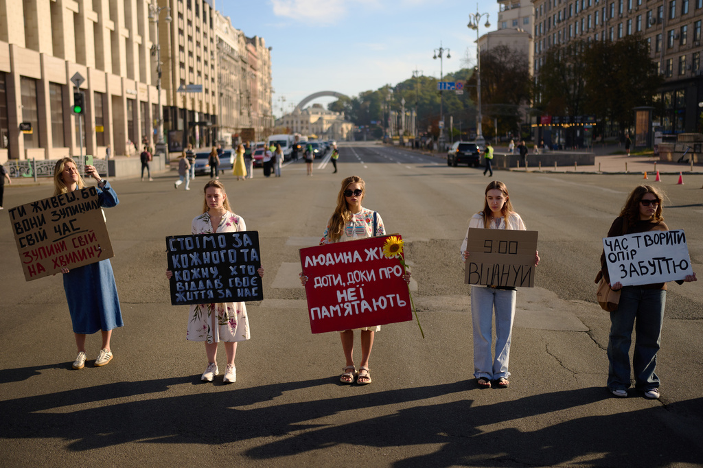 Women attend a daily nationwide minute of silence in memory of soldiers killed in the war with Russia at the Independence square in Kyiv, Ukraine, Saturday, Aug. 29, 2026, marking Ukraine's Defenders Remembrance Day. (AP Photo/Francisco Seco)