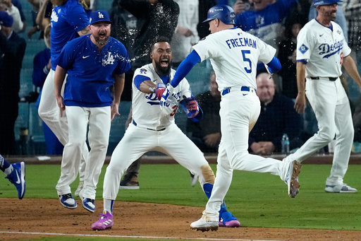 Los Angeles Dodgers' Teoscar Hernández throws water on Freddie Freeman (5) after Freeman hit a walk off home run during the 18th inning in Game 3 of baseball's World Series against the Toronto Blue Jays, Monday, Oct. 27, 2025, in Los Angeles. (AP Photo/David J. Phillip) Los Angeles Dodgers' Teoscar Hernández throws water on Freddie Freeman (5) after Freeman hit a walk off home run during the 18th inning in Game 3 of baseball's World Series against the Toronto Blue Jays, Monday, Oct. 27, 2025, in Los Angeles. (AP Photo/David J. Phillip)