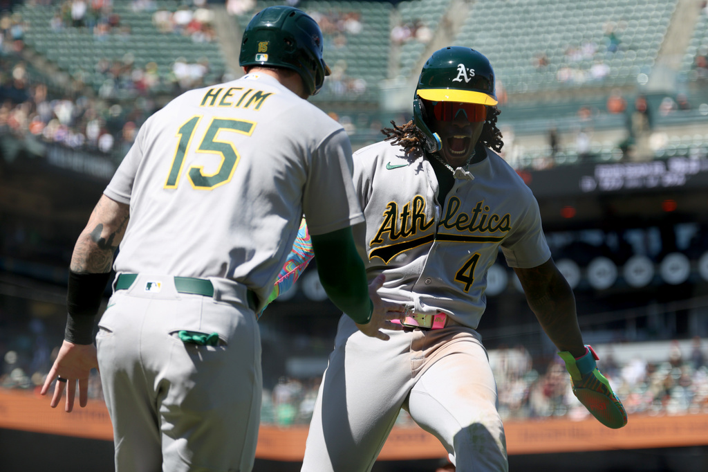 Athletics' Lawrence Butler (4) celebrates with Jonah Heim (15) after scoring on a single by Max Muncy during the ninth inning of a baseball game against the San Francisco Giants in San Francisco, Thursday, June 25, 2026. (AP Photo/Jed Jacobsohn)