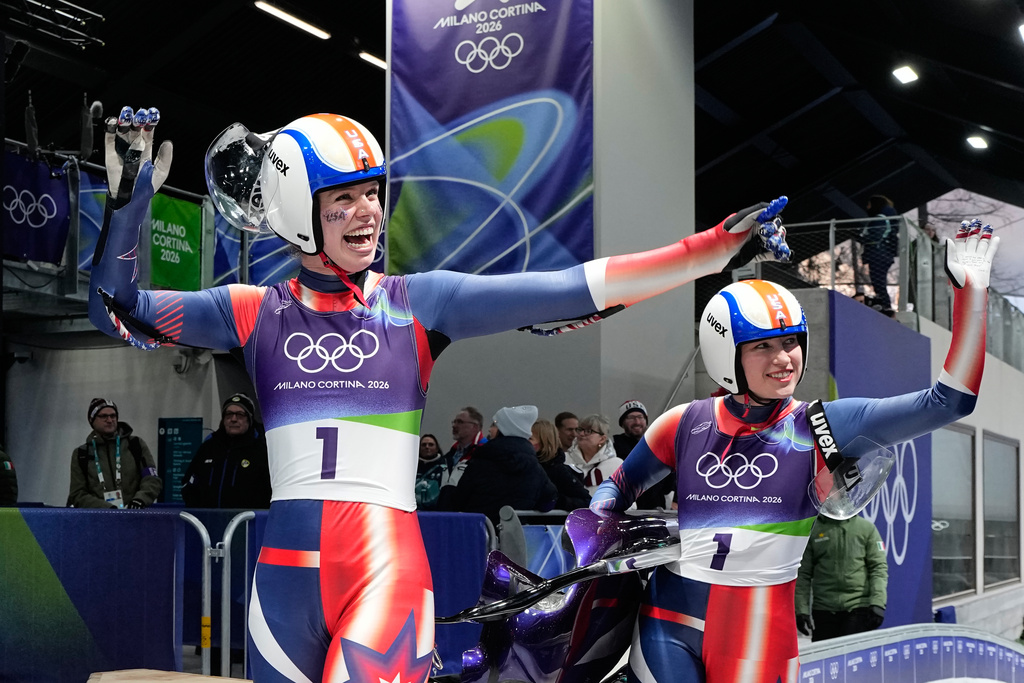 United States' Chevonne Forgan, left, and Sophia Kirkby, right, celebrate as they arrive at the finish during a women's doubles luge run at the 2026 Winter Olympics, in Cortina d'Ampezzo, Italy, Wednesday, Feb. 11, 2026. (AP Photo/Alessandra Tarantino)