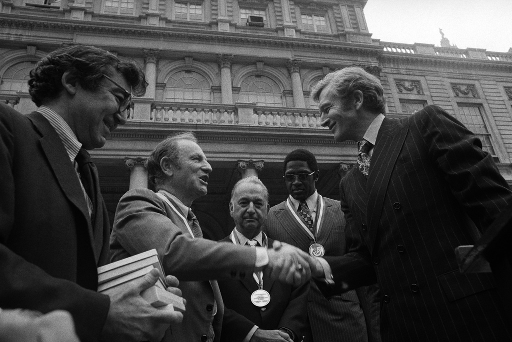 FILE - New York Mayor John Lindsay, right, congratulates Red Holzman, coach of the New York Knicks, after presenting the city's diamond jubilee medals to Holzman and other members of the Knicks team on the steps of City Hall on May 15, 1973. Shown with the mayor are Irving Felt, board chairman of Madison Square Garden, second from left, and Willis Reed, team captain, next to Lindsay. (AP Photo/Anthony Camerano, File)