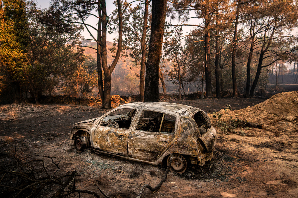 A burnt car sits in an area burned by a wildfire near Piedralaves, Ávila province, Spain, Wednesday, July 29, 2026. (AP Photo/Olmo Calvo)