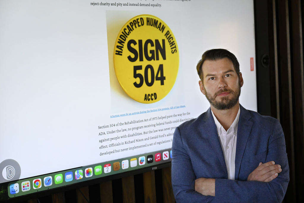 In this Sept. 3, 2025 photo, Samuel J. Redman, Ph.D., Professor of History and Director of the Public History Program at the University of Massachusetts, stands in front of content he uses from the Smithsonian on campus in Amherst, Mass. (AP Photo/Jessica Hill)