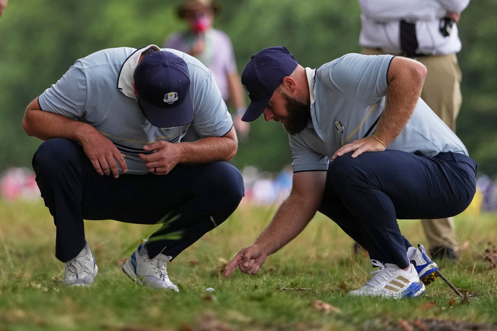 Europe's Tyrrell Hatton and Jon Rahm look at the ball in the rough on the seventh hole at Bethpage Black golf course during the Ryder Cup golf tournament, Friday, Sept. 26, 2025, in Farmingdale, N.Y. (AP Photo/Matt Slocum)